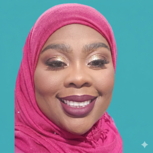 Hafeezah Muhammad smiling in a professional portrait, wearing a bright pink hijab with a solid teal backdrop.